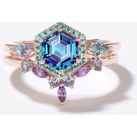 Bague de fiançailles en alexandrite taille hexagonale avec halo d'émeraudes