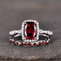 Bague de fiançailles en grenat avec halo de diamants et pierres latérales